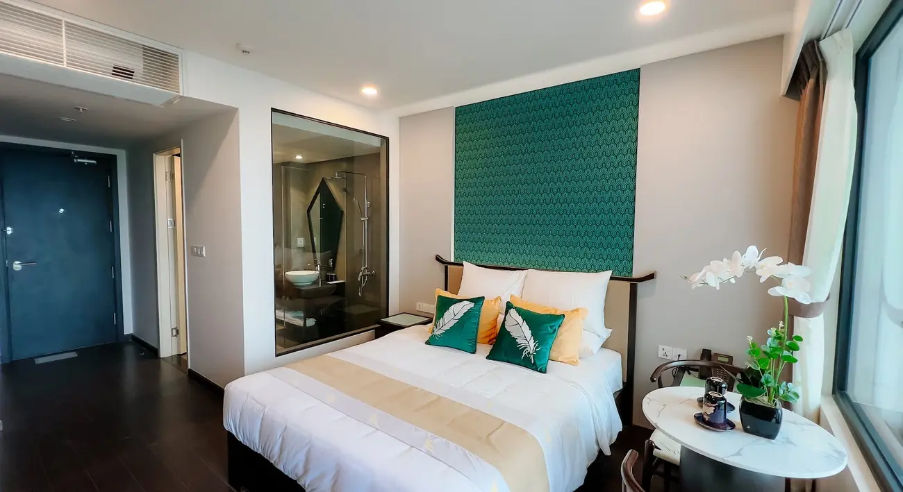 Phòng Deluxe giường đôi tường xanh, bàn trà và hoa lan – khách sạn Lynntimes Thanh Thủy