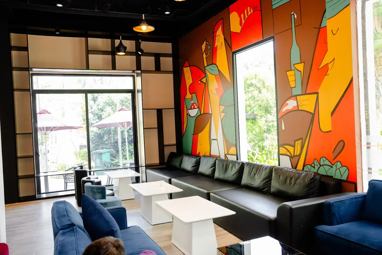 Phòng sinh hoạt chung Tatami Hotel với sofa và tranh tường màu sắc – Lynntimes Thanh Thủy