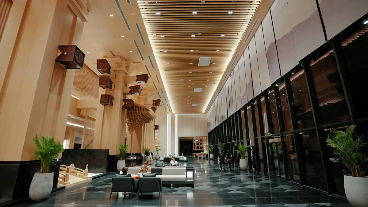 Sảnh khách sạn Lynntimes Thanh Thủy trần cao, vách nan gỗ và sofa trắng