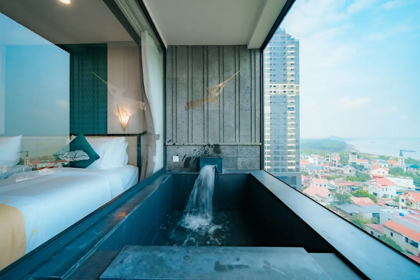 Bồn onsen đá đen nước chảy cạnh giường, cửa kính nhìn toàn cảnh thị trấn – Lynntimes Thanh Thủy