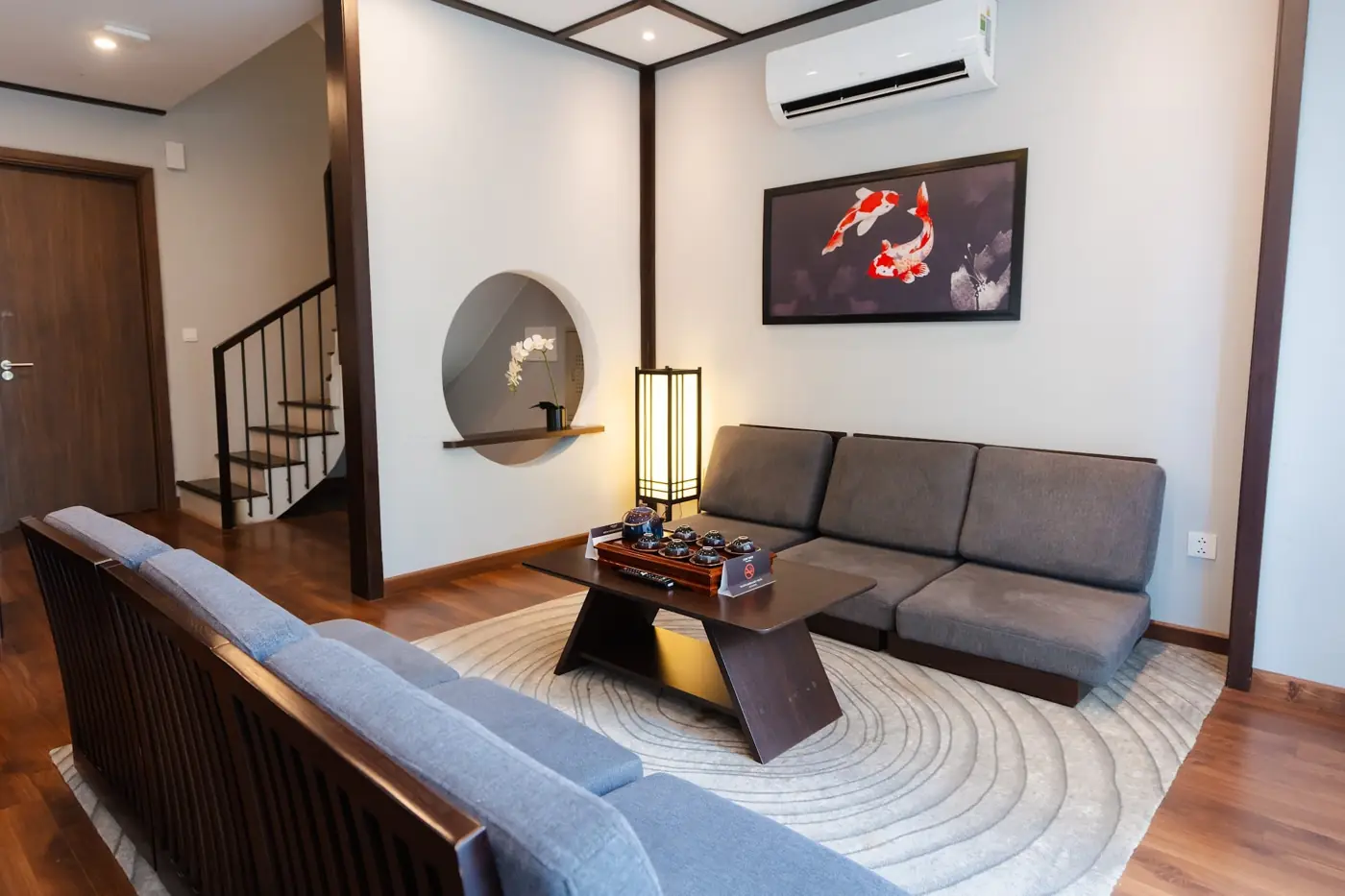 Phòng khách Shoptel có cầu thang, sofa và tranh cá Koi – Lynntimes Thanh Thủy